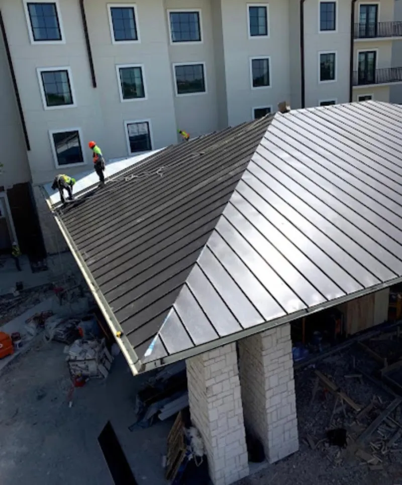 Crew installing standing seam metal roof panels on a commercial project in Ruskin